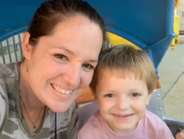 Jodi and her son Reid, who is being treated for SBS with GATTEX, smiling together outdoors