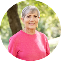 Peggy, an SBS Connect mentor living with short bowel syndrome, smiling outdoors in a pink top